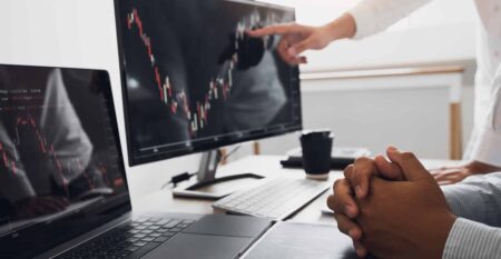 Two business partnership discussing and analysis with stock grap